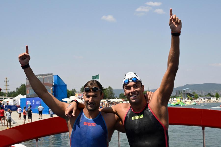 epa10041034 Winner Gregorio Paltrinieri of Italy (R) and his second-placed compatriot Domenico Acerenza (L) celebrate after the men's open water 10km swimming race of 19th FINA World Championships in Lake Lupa in Budakalasz, Hungary, 29 June 2022.  EPA/Zsolt Szigetvary HUNGARY OUT