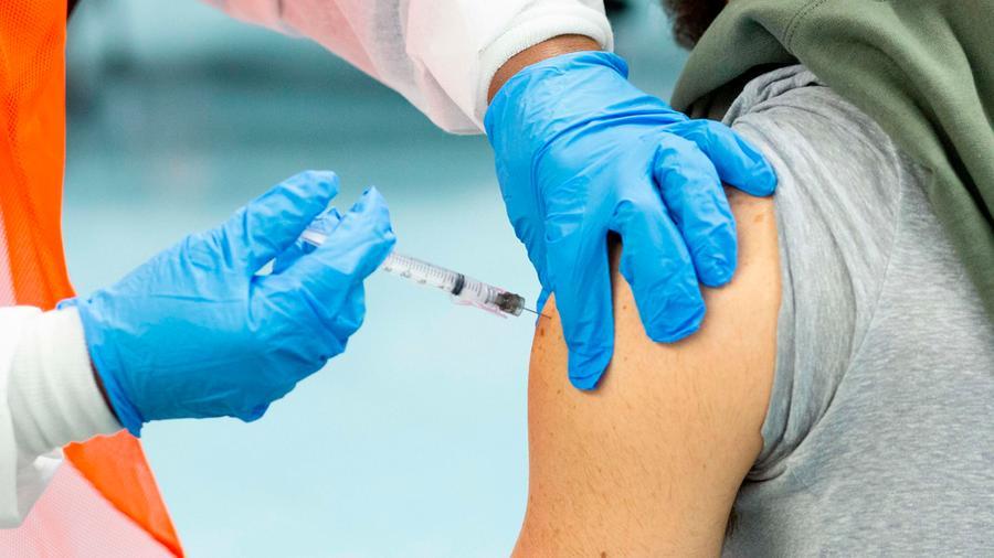 (FILES) In this file photo a man receives a dose of the Moderna coronavirus disease (COVID-19) vaccine at a vaccination site at South Bronx Educational Campus, in the Bronx New York on January 10, 2021. - US biotechnology firm Moderna on January 25, 2021 said lab studies showed its Covid-19 vaccine would remain protective against variants of the coronavirus first identified in the United Kingdom and South Africa. "The study showed no significant impact" on the level of neutralizing antibodies elicited against the UK variant, B.1.1.7. (Photo by Kena Betancur / AFP)