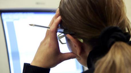 Un'impiegata davanti allo schermo del computer nel suo ufficio durante l'orario di lavoro, in una foto di archivio. ANSA/ FILIPPO MONTEFORTE