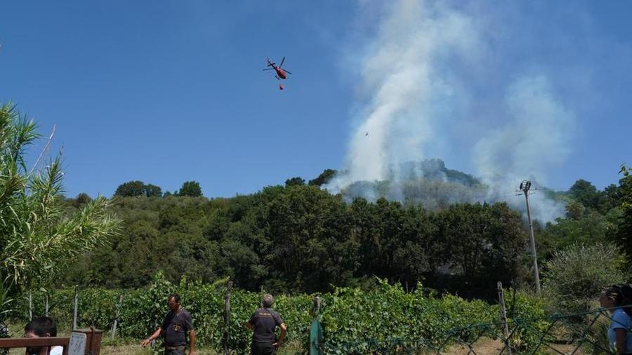 L'incendio sopra la frazione di Forcoli, con i lanci dell'elicottero (foto Silvi)