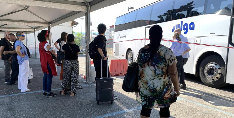 Viaggiatori in attesa di salire su un bus navetta ieri alla stazione ferroviaria di Pistoia