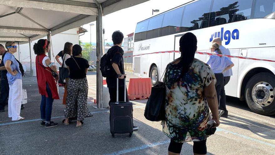Viaggiatori in attesa di salire su un bus navetta ieri alla stazione ferroviaria di Pistoia