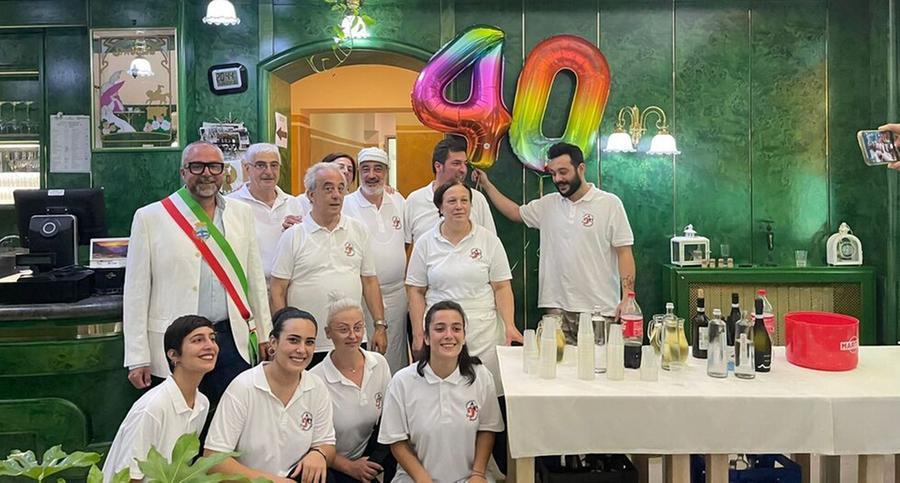 Sopra il sindaco di Pontedera Matteo Franconi con il gruppo del Gambero tra proprietari familiari e  dipendenti del ristorante pizzeria sul Piazzone a Pontedera