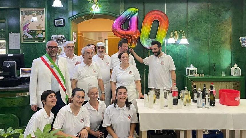 Sopra il sindaco di Pontedera Matteo Franconi con il gruppo del Gambero tra proprietari familiari e dipendenti del ristorante pizzeria sul Piazzone a Pontedera