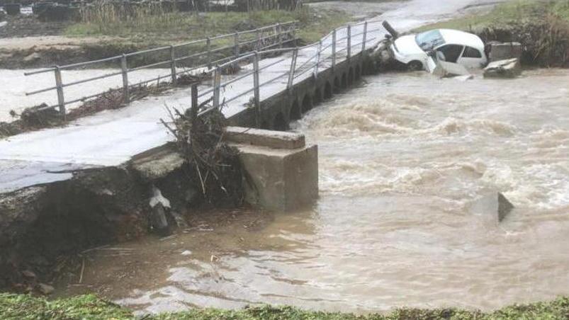 La vecchia passerella durante la piena del febbraio 2019. Visibile l’auto travolta dalle acque
