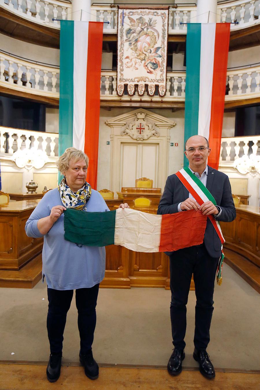 
	La bandiera del &ldquo;Solitario&rdquo; consegnata al sindaco di Reggio Luca Vecchi da Chiara Morelli, nipote del partigiano e giornalista Giorgio Morelli

