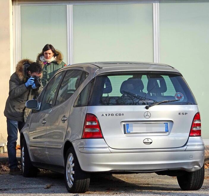 Due agenti della polizia scientifica al lavoro su una bottiglia di gasolio lasciata su un’auto in sosta in un posteggio (immagine d’archivio)