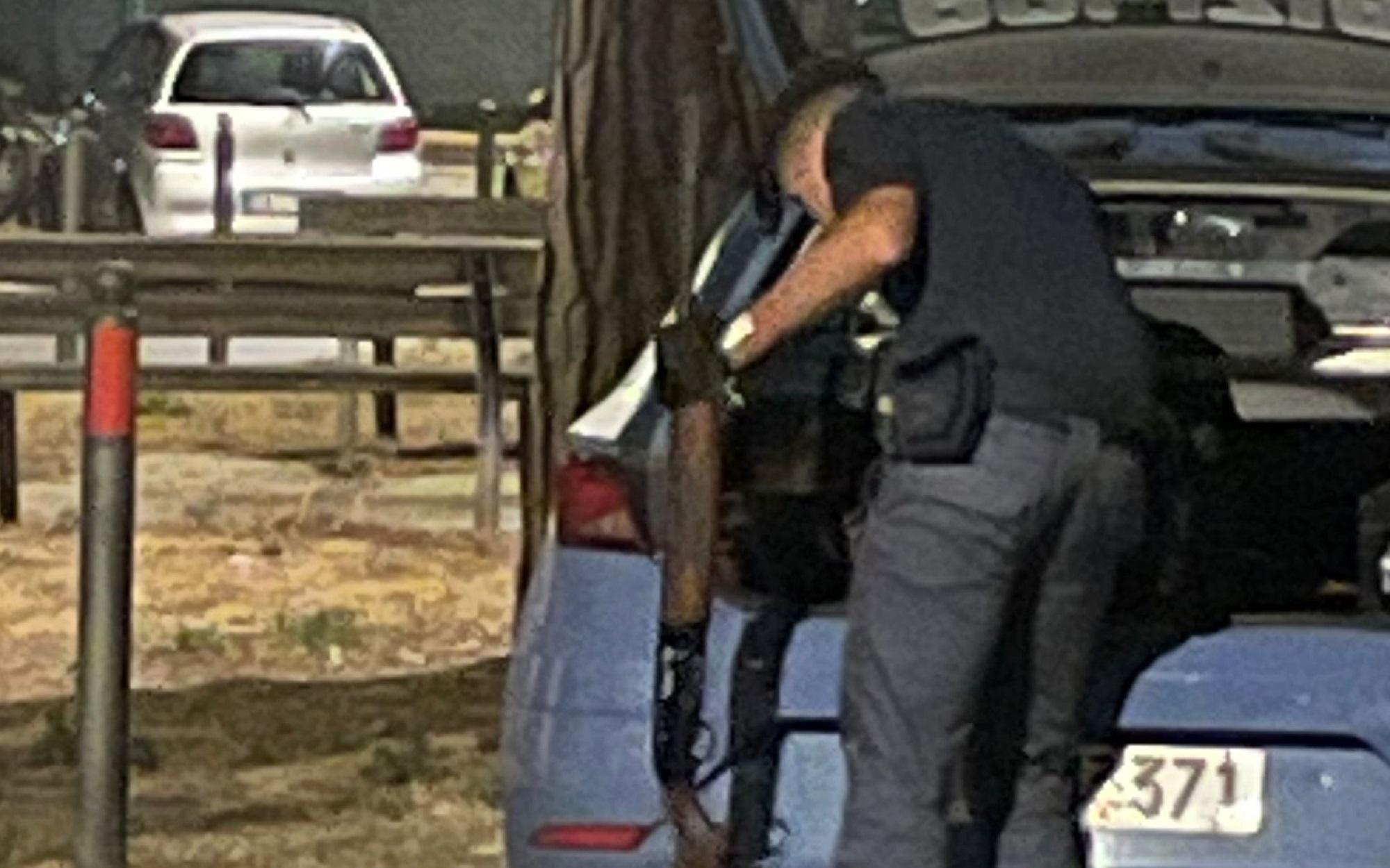 Un poliziotto mentre sequestra un fucile