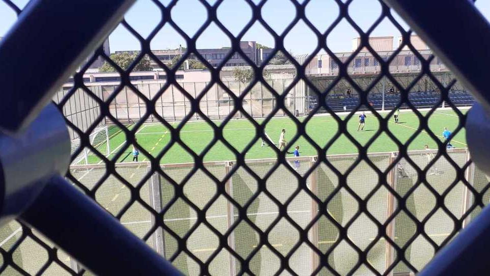 Detenuti che giocano visti da una cella delle Sughere Sotto: “Il mio canto libero” scritto in un corridoio