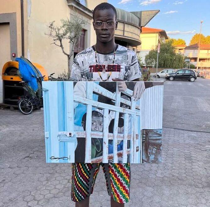 Ebrima Dianso davanti alla parrocchia di Vicofaro con il suo ultimo quadro