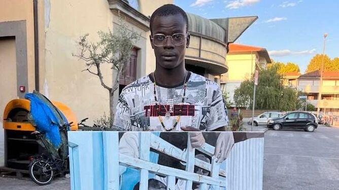 Ebrima Dianso davanti alla parrocchia di Vicofaro con il suo ultimo quadro