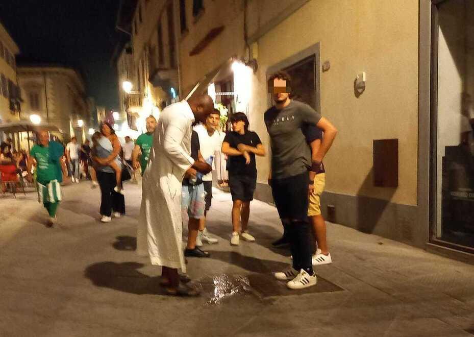 L’uomo rapinato (vestito di bianco) soccorso da alcuni passanti