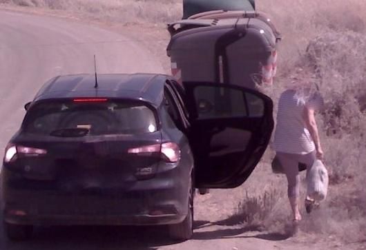 L’immagine ripresa da una videocamera di una persona sorpresa a gettare rifiuti speciali in un cassonetto di Alia al bordo di una strada