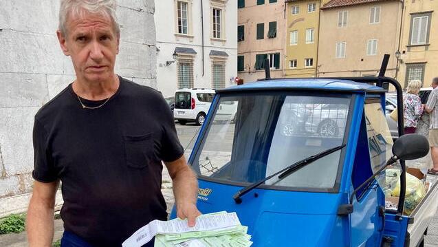 Roi Pantaleoni con in mano le multe e dietro l’Ape Piaggio che usa per entrare in centro
