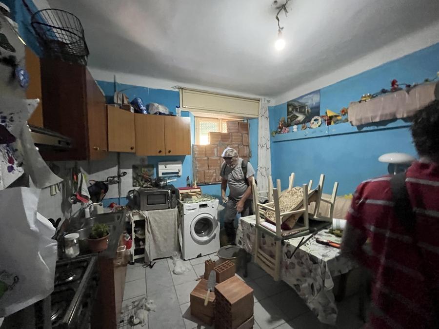 
	Un operaio mentre mura la finestra dell'appartamento sgomberato (foto Franco Silvi)

