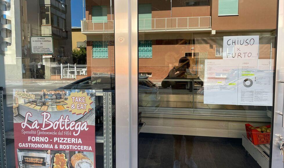 Nella foto il cartello, con le bollette della luce, al negozio di gastronomia, pizzeria e rosticceria “La Bottega”  in via Litoranea