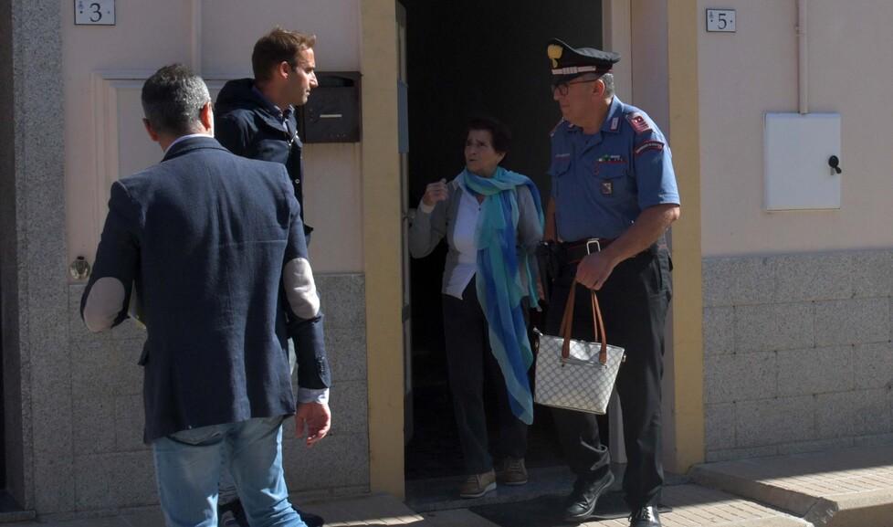 Efisia Aiello esce dalla casa tenuta per mano dal comandante dei carabinieri