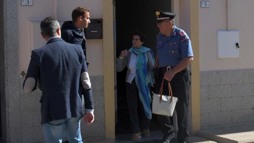 Efisia Aiello esce dalla casa tenuta per mano dal comandante dei carabinieri