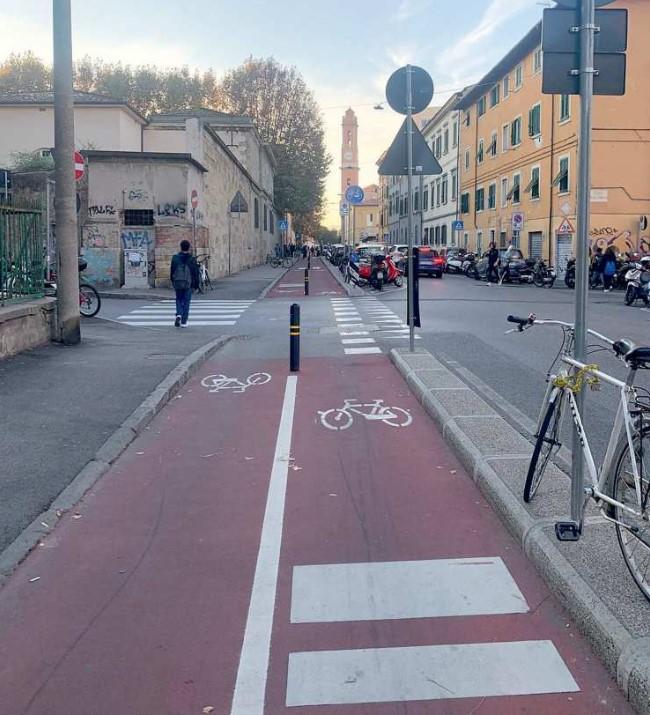 La pista ciclabile di via Galilei ieri mattina e alcuni dei tanti scooter parcheggiati in divieto