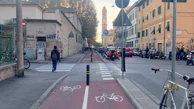 La pista ciclabile di via Galilei ieri mattina e alcuni dei tanti scooter parcheggiati in divieto