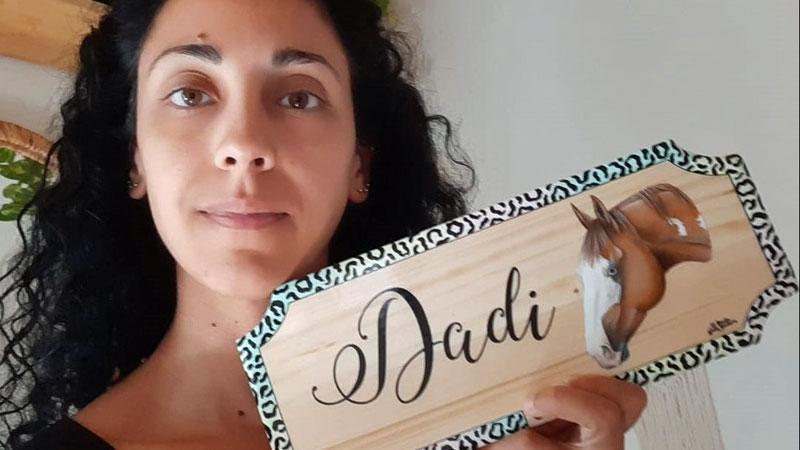 Lavinia Giuntini mostra la targa in legno realizzata per il cavallo Dadi