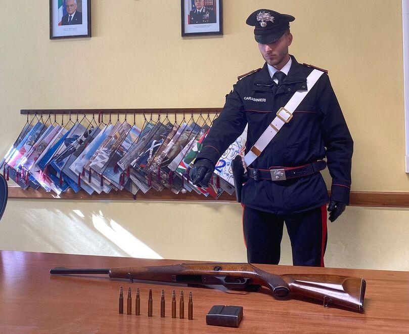 Un carabiniere indica arma e munizioni sequestrate al cacciatore di frodo