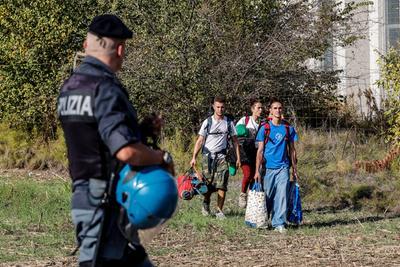 
	Un agente osserva un gruppo di raver che lascia il capannone. Erano 3mila i giovani che partecipavano al party

