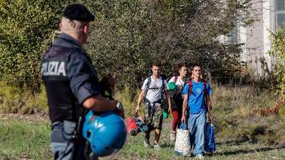 Un agente osserva un gruppo di raver che lascia il capannone. Erano 3mila i giovani che partecipavano al party