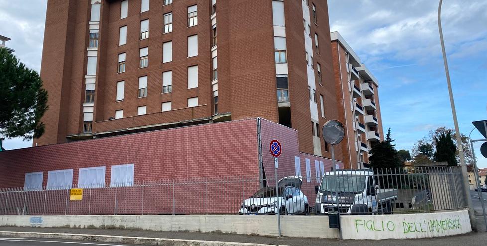 Nella foto in alto i pannelli a finti mattoncini e finestre che ora coprono il piano terra del palazzo in zona militare tra via Goito e via Orlandi