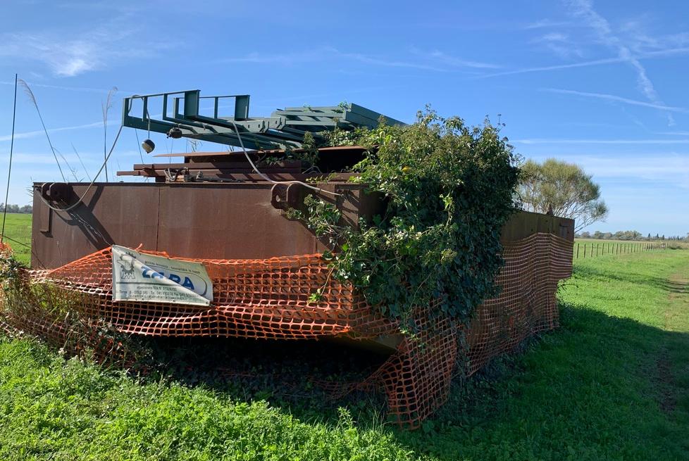 La chiatta comprata dal Comune nel 2004 e da allora ferma in un campo privato a Marina di Alberese