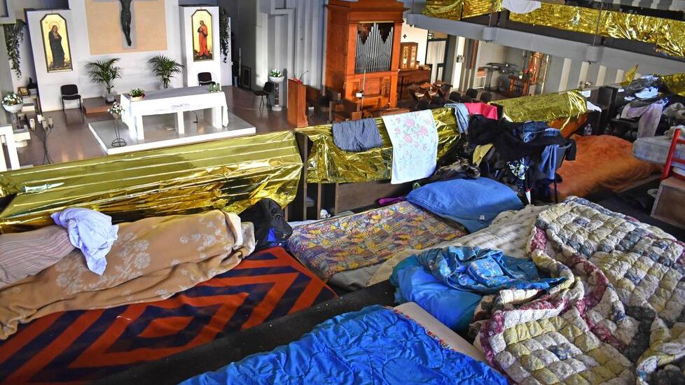 I letti dei migranti nel matroneo, la platea sul soppalco della chiesa di Santa Maria Maggiore (foto Gori)