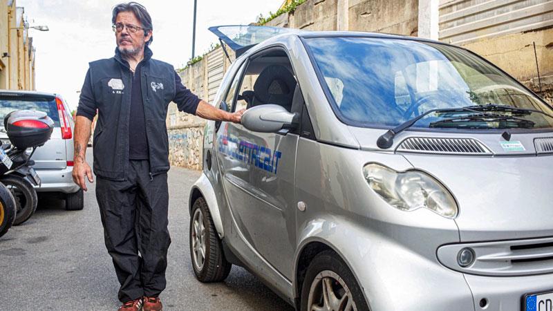 Alex Sonaglia vicino  all’ingresso della propria officina spiega come è fatta la Smart made in Sonoelettrica una vettura speciale rispetto a tutte le altre auto trasformate in commercio