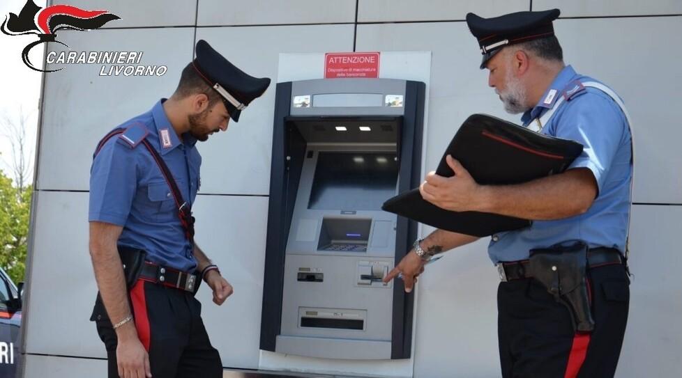 I carabinieri davanti al bancomat utilizzato per la transazione risoltasi con un raggiro per l’acquirente