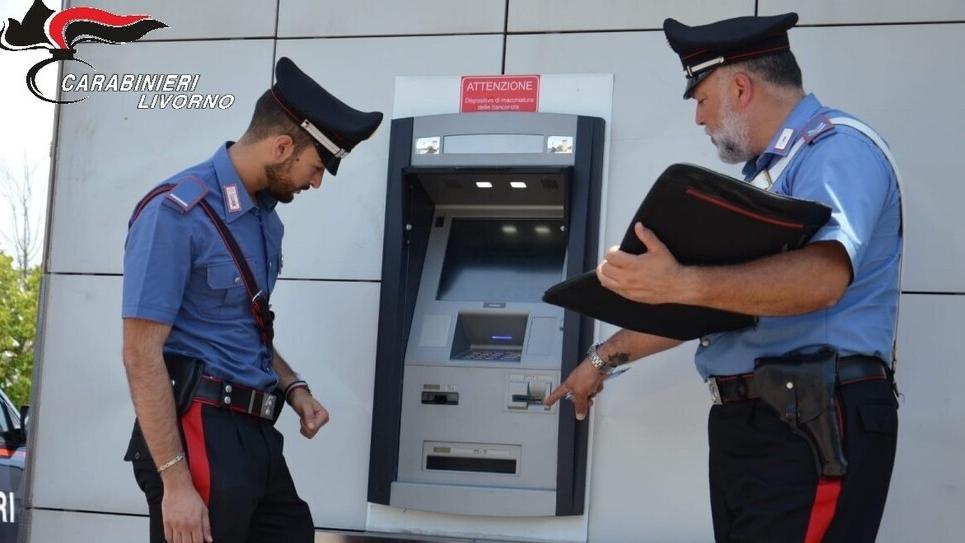 I carabinieri davanti al bancomat utilizzato per la transazione risoltasi con un raggiro per l’acquirente