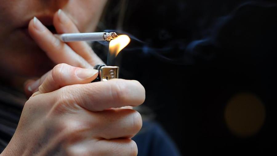 Una donna accende e fuma una sigaretta.&nbsp; ANSA/LAUDIO ONORATI