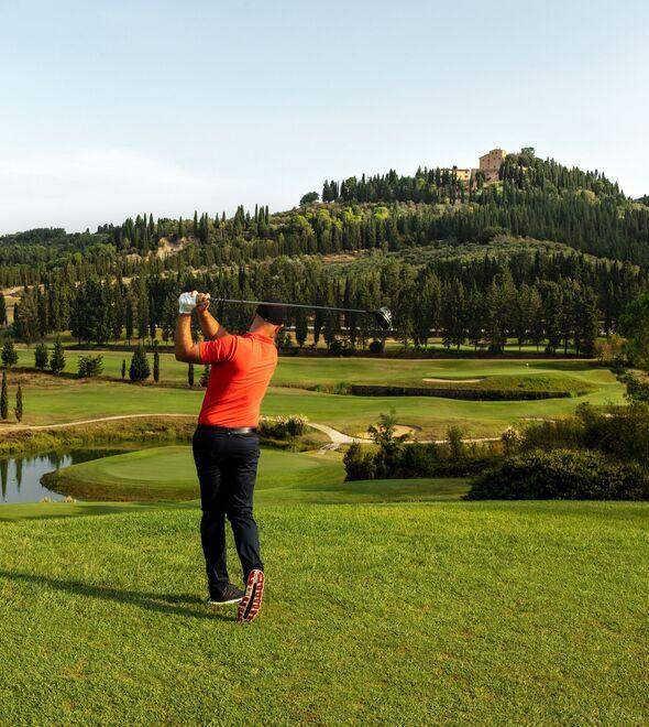 Una immagine del campo da golf della tenuta di Castelfalfi e sullo sfondo il borgo dove si trova il resort