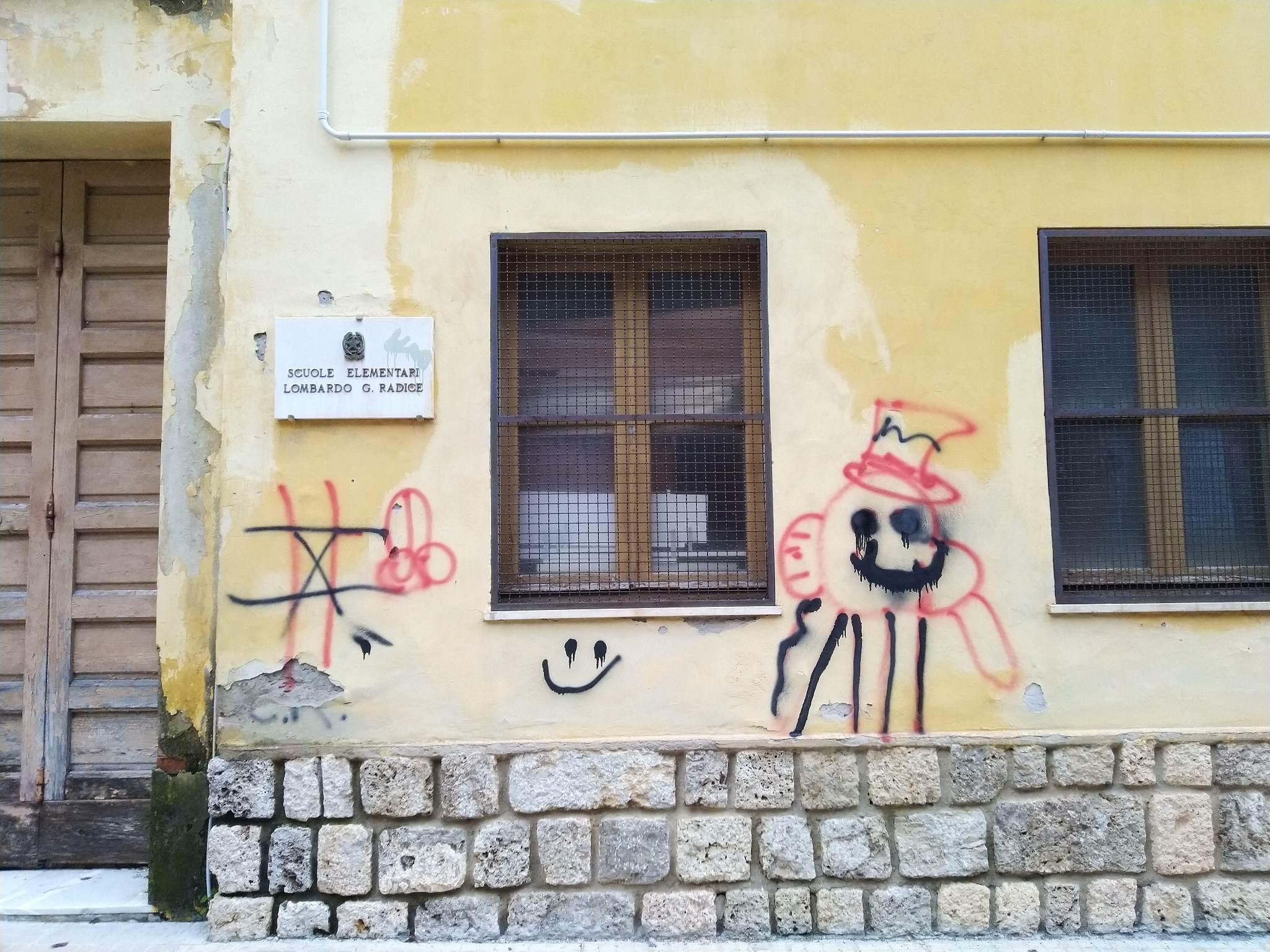 Scritte e disegni vandalici sulle pareti della ex scuola abbandonata