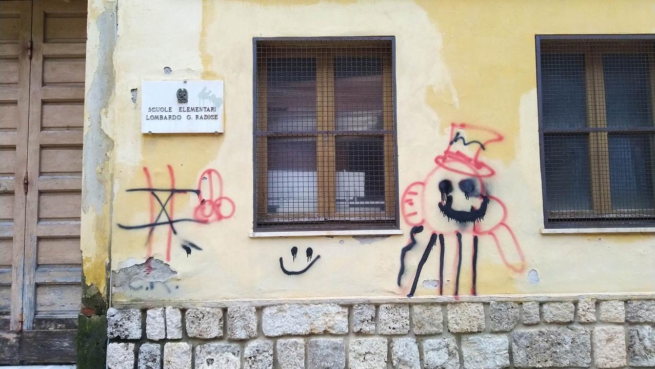 Scritte e disegni vandalici sulle pareti della ex scuola abbandonata