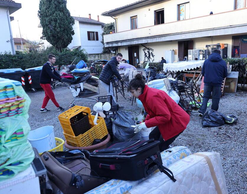 Gli scout di Rimini aiutano a portare rifiuti fuori dalla canonica (foto Nucci)