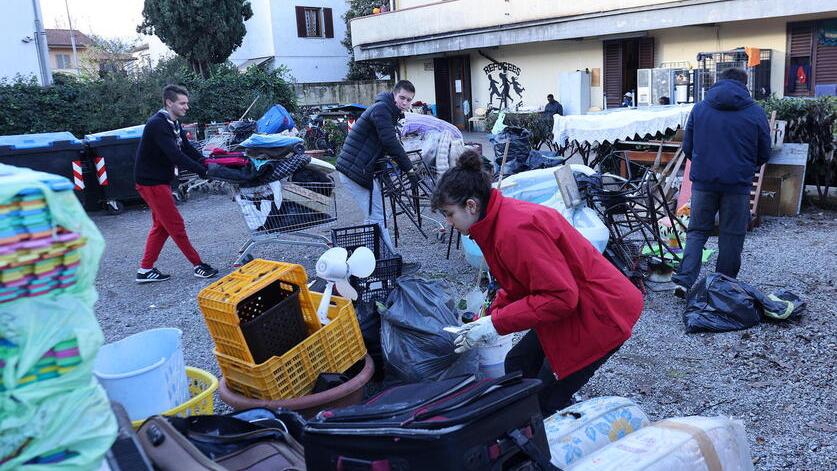 Gli scout di Rimini aiutano a portare rifiuti fuori dalla canonica (foto Nucci)