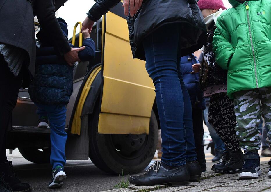 Bambini salgono su uno scuolabus