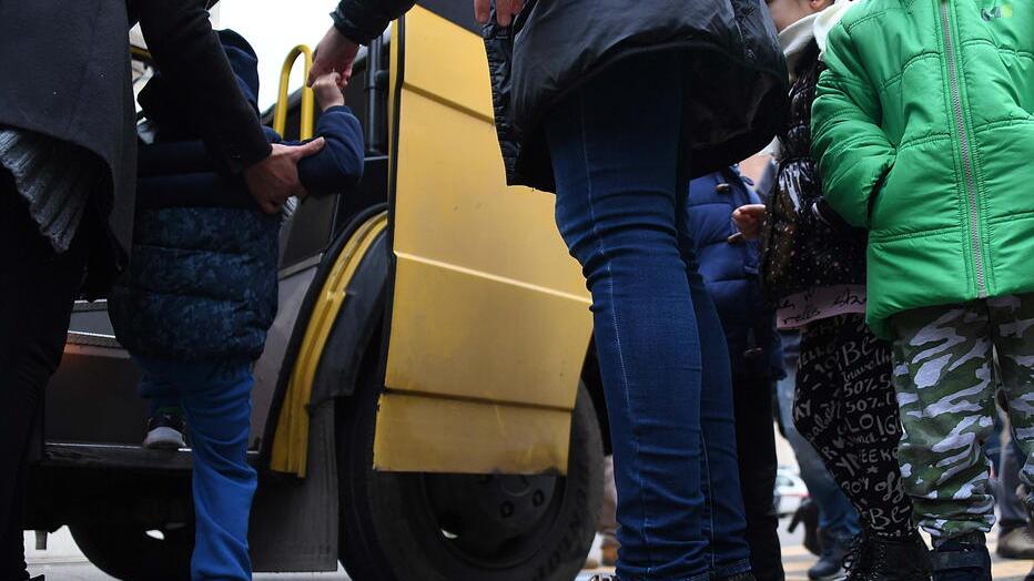 Bambini salgono su uno scuolabus