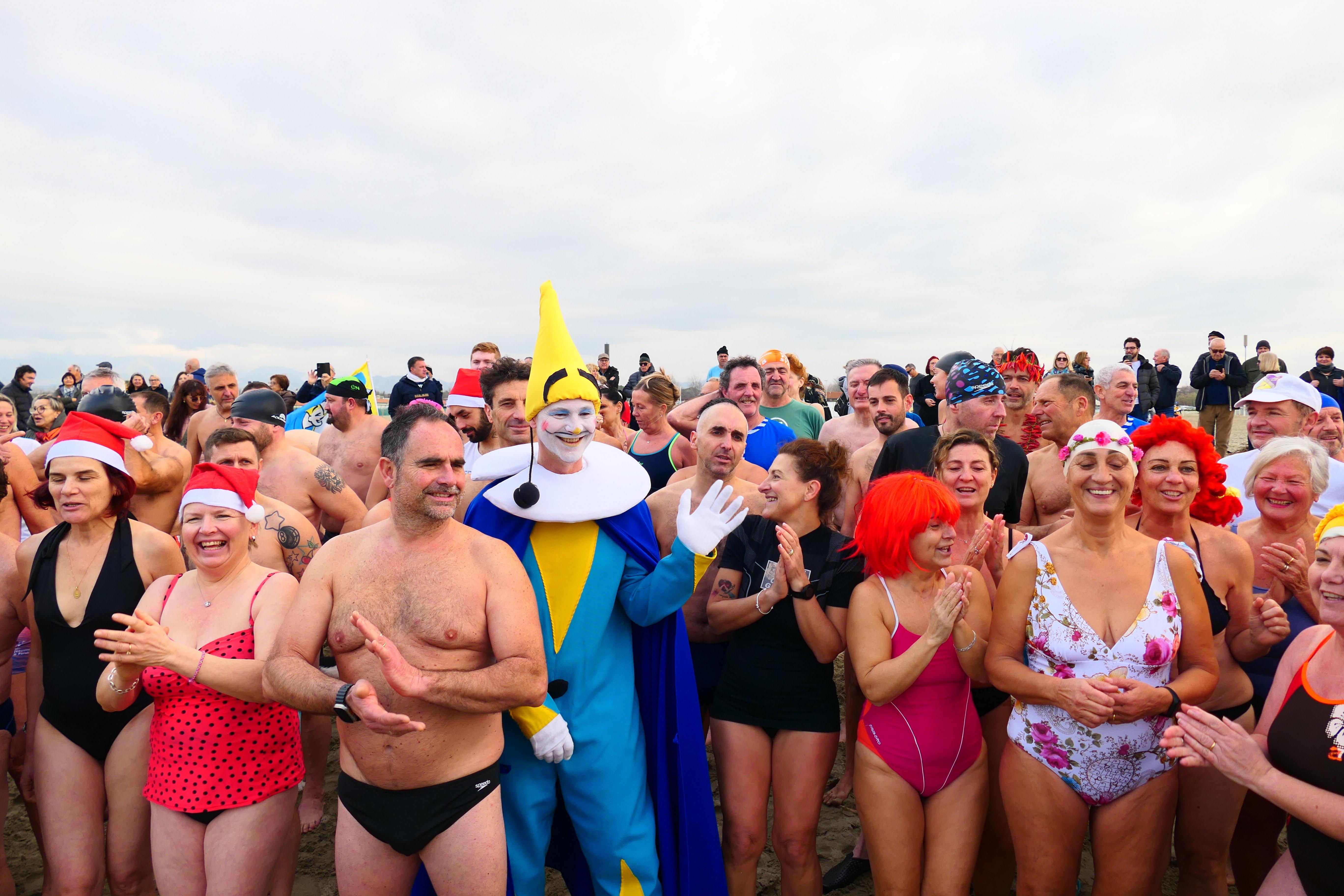 I partecipanti al tuffo di Capodanno di Torre del Lago ai nastri di partenza e poi, dopo il via, tutti in acqua a salutare il 2023 (fotoservizio Pagilianti)