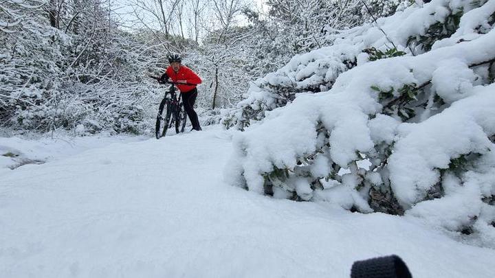 Un ciclista sul monte Ortobene durante una nevicata del febbraio 2022