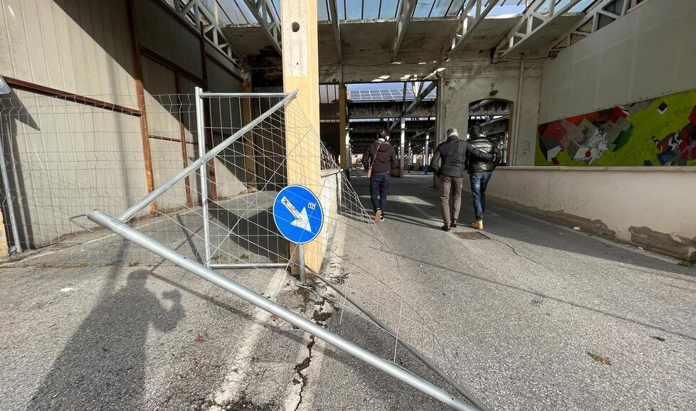 Nella foto grande la rete di metallo divelta e il passaggio di persone sotto alle travi che sono state dichiarate pericolanti da più esperti del settore