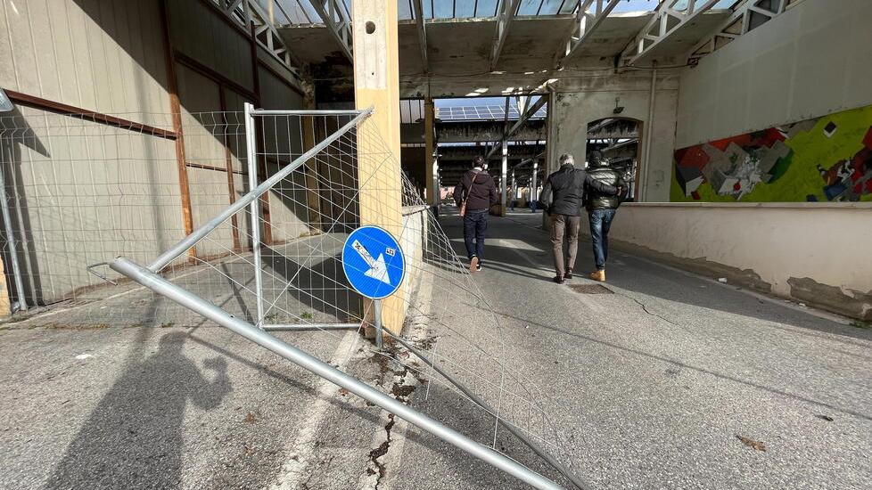Nella foto grande la rete di metallo divelta e il passaggio di persone sotto alle travi che sono state dichiarate pericolanti da più esperti del settore