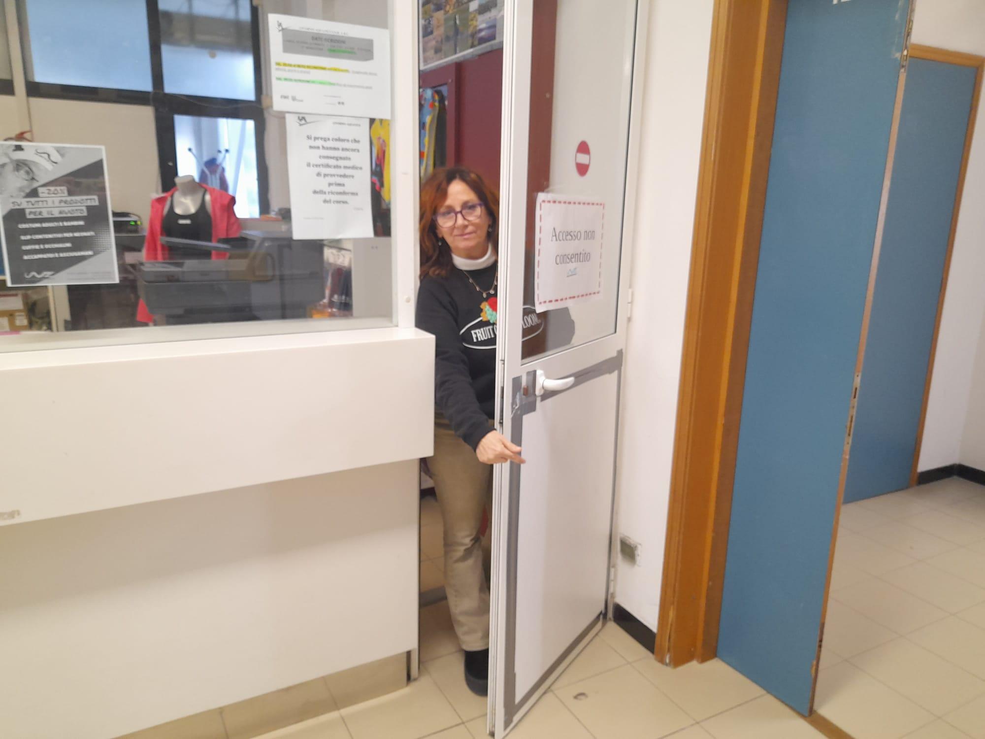 Una dipendente indica la porta riparata