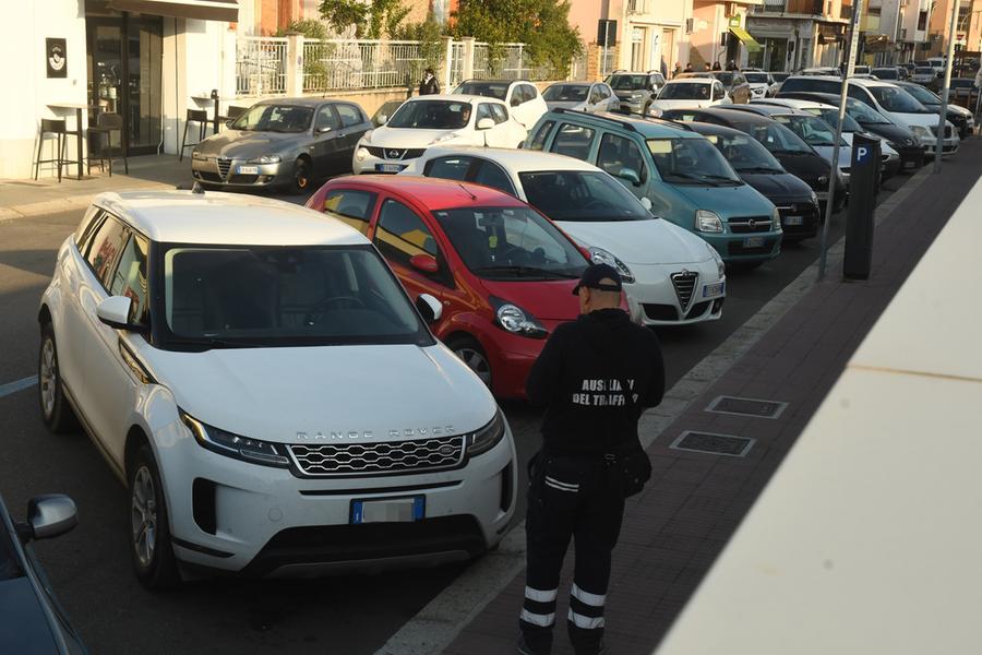 
	Un ausiliario del traffico controlla le auto negli stalli blu

