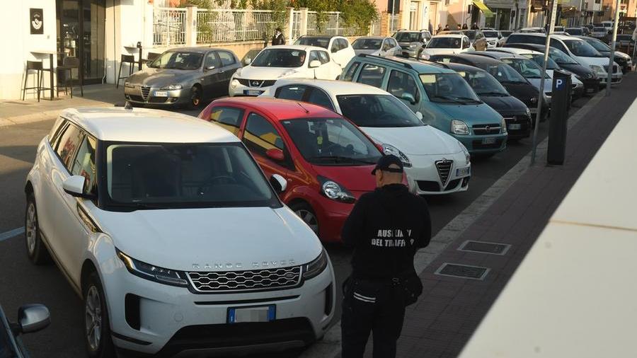 Un ausiliario del traffico controlla le auto negli stalli blu