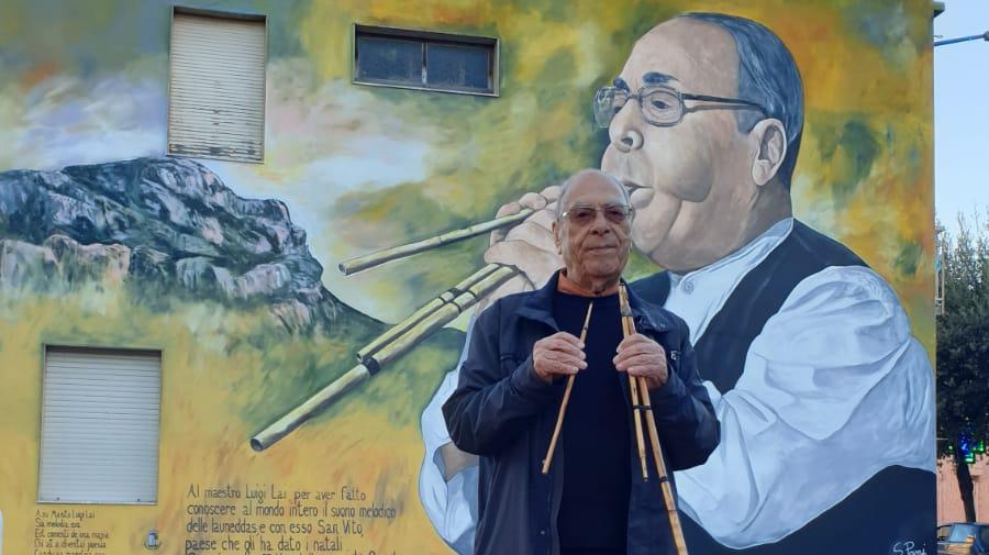Il maestro Luigi Lai davanti al murale che lo ritrae
